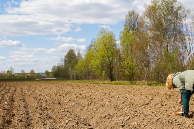 Woman planting onion on soil. Human hands taking care of a seedling in the soil. New sprout on sunny day in the garden in summer. Female agronomist testing a quality of soil. Concept of agriculture.