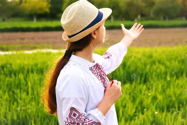 Welcome Ukraine. Young ukrainian woman portrait. Meadow nature background. Showing sign love Ukraine. Smiling ukrainian girl showing gesture love. Vyshyvanka. Invitation Ukraine. Out of focus.