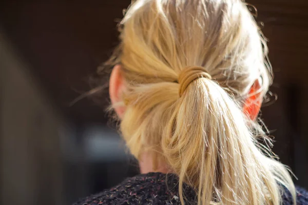 stock image Yellow hair with ponytail. Portrait Of Beautiful Middle Age Blond Woman With Pony Tail. view from the back. Closeup. Out of focus.