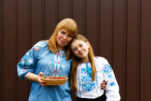 Easter family. Mother and daughter holding Easter eggs and hugging. Looking at camera. Ukrainian people. Out of focus.