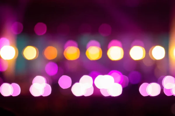 Festive purple spotted glitter background. Defocus blurred abstract purple bokeh background. Blurry music performance in rock band concert. Light holiday. Out of focus.