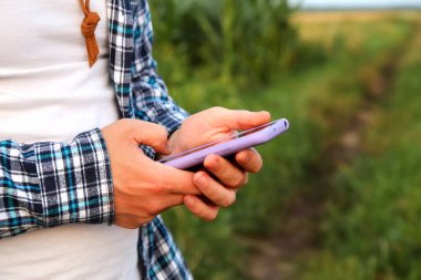 Çiftçiler telefon kullanıyor. Tarım işi. Hasat. Cep telefonuyla, çiftçi tarım raporunu dikkatle kontrol ederek, çiftliklerinin yönetimindeki teknolojinin gücünü kucaklıyor..