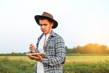 Çiftçi tableti. Güneşli bir hava. Ekinlerin, çiftlik hayvanlarının ve diğer tarım ürünlerinin ekimi, üretimi ve dağıtımında rol alan tarım sektörü kavramı.