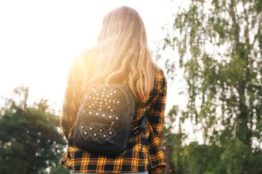 Sırt çantalı kadın. Ormanda sırt çantalı hippi kız. Gezgin geçmişi. Turist yaz yaşam tarzı. Bulanık. Sarı kıvırcık saçlı. Ergen tarzı. Yürüyüş. Yürüyen doğa.