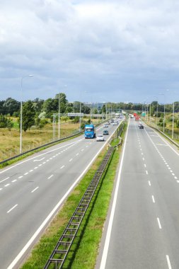 Pist otoyolu. Dikey. Otoyol, otomobil endüstrisi reklamları için ideal olan günlük ulaşım ve ulaşım ağını gösteren iki şeritli araçlar ve kamyonlarla dolu..