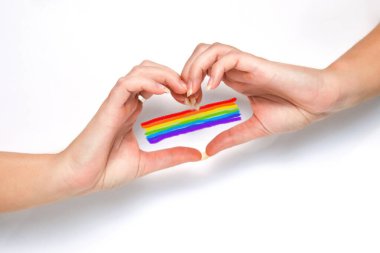 Gökkuşağı yürekli el, LGBTQ hakları, gurur ayı. Beyaz arka plan. Kadın elleri kalp hareketi yapıyor. Renkli gurur bayrağı, LGBTQ sevgisinin sembolü, kutlama.