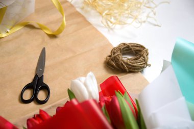 Çiçekler taklit eder. Kağıt üzerinde çiçekler ve makasla kompozisyon. Laleler, çiçekler, makas ve el işi kâğıdı arka planda ip. Odaklanamıyorum.