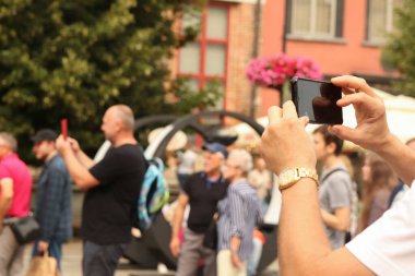 El ele tutuşmak, fotoğraf çekmek, seyahat anıları. Fotoğraf çek, el ele tutuşup telefon et, seyahat anıları canlandır. Bulanık şehir yaz arkaplanı.