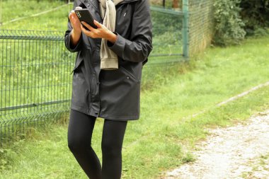 Kadın telefonu, açık hava navigasyonu. Akıllı telefon dokunmatik ekranı, dışarıda gezinen kadın. Açık hava aktiviteleri ve akıllı telefon kullanımı.