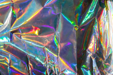 Renkli holografik arka plana sahip parlak folyo, pembe ve gökkuşağı folyo deseni, hologram efektli parıldayan folyo. Folyo dokusu.