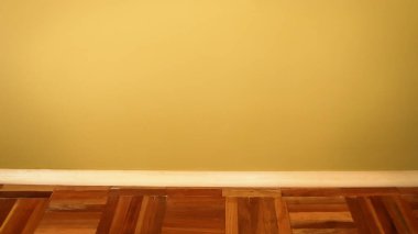 Minimalist bir pankartta zeytin rengi bir duvarın ahşap parke döşemesi ve kamışı var. Zeytin duvarının doğal tonları ve ahşap elementler sakin ve dünyevi bir atmosfer yaratır..