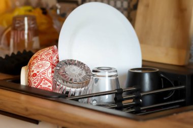 İçi pırıl pırıl temiz tabaklarla dolu el değmemiş bir lavabo. Temiz bir tabak, temiz bir bardak ve taze bir bardak da dahil..