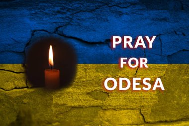 Rusya 'nın bombardımanından sonra Odesa' da bir mum ve bir Ukrayna bayrağının güçlü ve kasvetli bir görüntüsü. Ukrayna bayrağı anma töreni. Odesa Anıt Mumları.