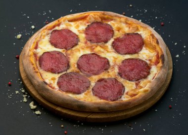 Salam koyu ahşap arka plan üstten görünüm üzerinde İtalyan biberli pizza. Geleneksel İtalyan yemekleri.