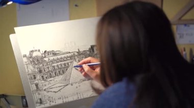 creativity and enthusiastic people concept - happy female artist with easel, pen liner draws graphic image of louvre building at home