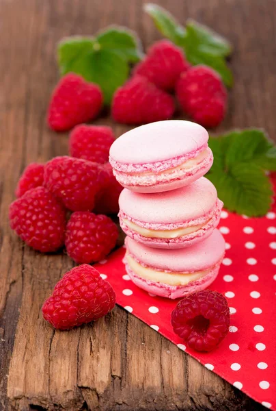 Pink raspberry macaron cookies on dark wooden boards