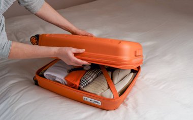 woman folding clothes to prepare her luggage. tourist woman preparing her suitcase for business trip.