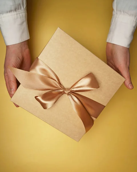 Een Gele Platte Achtergrond Handen Houden Een Geschenk — Stockfoto