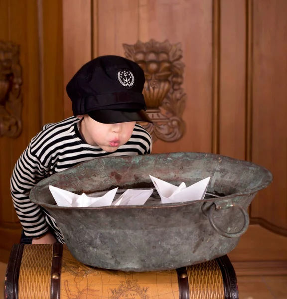 一个孩子在家里把纸船放在一碗水里 — 图库照片