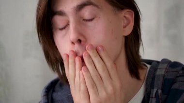 Adamın gözleri bilgisayarın başında uzun süre çalışmaktan yorulmuş ve yaralanmış. Çerçeveye bakıp, evinde gülümseyen genç bir adamın portresi.