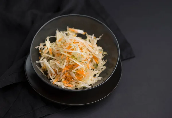 Stock image Cabbage salad. Homemade salad of cabbage, carrots and apples in a wooden bowl on a dark background top view.