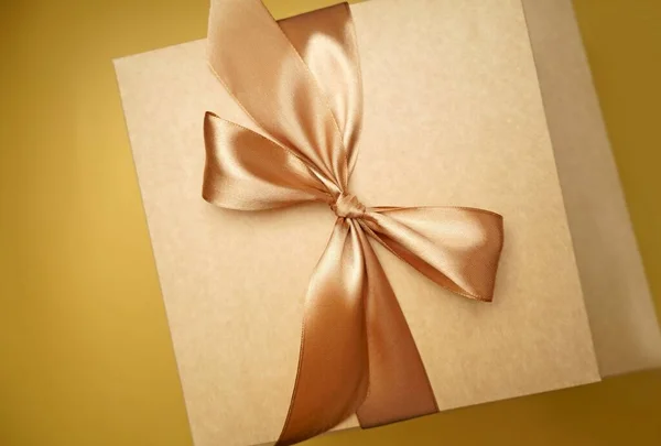 Een Vierkante Geschenkdoos Ambachtelijk Papier Gele Strik Linten Papieren Achtergrond — Stockfoto