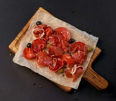 Pirzola - jambon, jambon, siyah arka planda tahta üzerinde salam