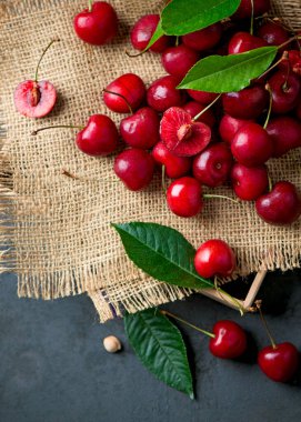 Siyah arka planda kiraz. Masanın üzerinde, siyah bir arkaplana karşı büyük bir kiraz bolluğu. yakın plan.