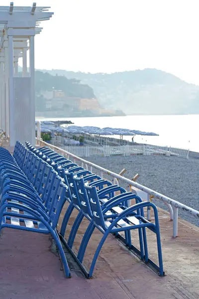 Nice, France - Famous blue chairs on the Promenade des Anglais in Nice Blue chairs on the beach.