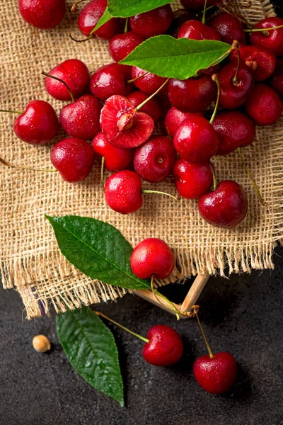 cherry on a black background. A large abundance of cherries on a table, against a black background. close-up.