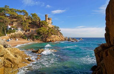 İspanya. Costa Brava kıyıları. Katalonya. Lloret de Mar. Akdeniz 'de. Güzel kayalar. Bir deniz dalgası kıyıya vuruyor.