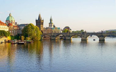 Prag - Charles Bridge, Çek Cumhuriyeti. Çek Cumhuriyeti 'nin Prag kentindeki Vltava Nehri üzerindeki Eski Şehir İskelesi ve Charles Köprüsü' nün mimarisi üzerinde manzaralı gün batımı.