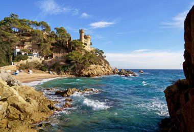 İspanya. Costa Brava kıyıları. Katalonya. Lloret de Mar. Akdeniz 'de. Güzel kayalar. Bir deniz dalgası kıyıya vuruyor.