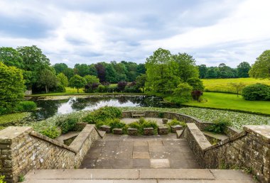 14 Haziran 2024 - Kendal, UK: Evden Sizergh Kalesi 'ndeki göle doğru uzanan büyük adımlardan yola çıkarak kırsal alan.