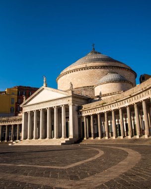 Napoli, İtalya 'daki Piazza del Plebiscito' nun tarihi mimarisi ve parke taşı desenleri gün doğumunda berrak mavi gökyüzünün altında.