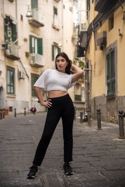 Napoli 'nin tarihi merkezinde kendine özgü bir sokakta poz veren şık bir genç kadın.