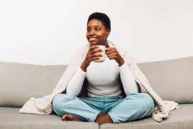 person sitting on a sofa and drinking coffee