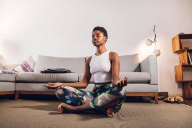 Evde yoga yapan bir kadın.