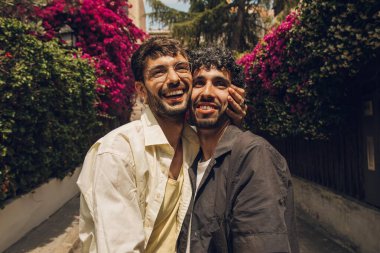 Açık havada birbirini kucaklayan birbirine aşık eşcinsel çift. Eşcinsel bir çiftin yakın plan portresi..