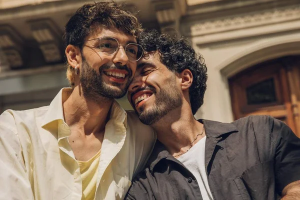 stock image men sitting on a bench in the city kissing ang huging each other