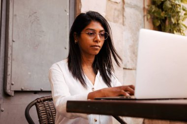 Dışarıda dizüstü bilgisayarı olan Hintli genç bir kadın. Yüksek kalite fotoğraf