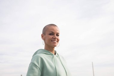 Bankta oturmuş gülümseyen mutlu kel kadın. Yüksek kalite fotoğraf