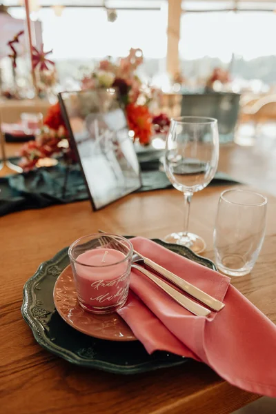 절단기가 테이블 위에는 분홍색 포크와 금장식이 접시가 위에는 분홍색 촛불이 — 스톡 사진