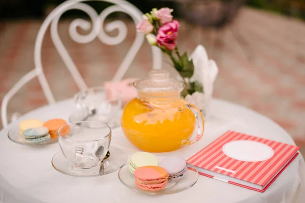 탁자가 카페에 유리판 수저가 있습니다 하나의 판에는 마카롱 근처에 오렌지 — 스톡 사진