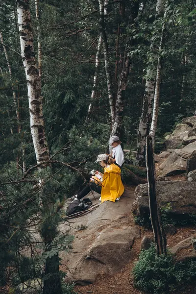 노란색 비옷을 어머니와 여행자의 앉아서 쿠키를 있습니다 — 스톡 사진