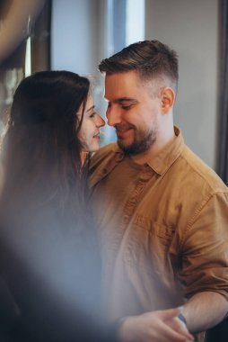 Evli bir çift, bir erkek ve bir kız karşı karşıya duruyorlar. Adam nazikçe kızın elini tutuyor. Gülümsüyorlar. Bulanık arkaplan ve arkaplan