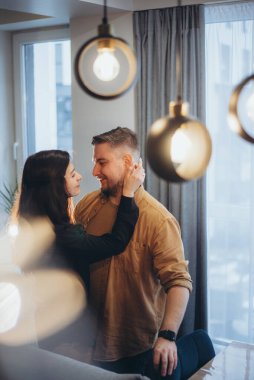 Evde, mutfakta evli bir çift. Kız adamın yüzüne bakar ve eliyle boynunu tutar. Bir adam bir kıza bakar ve gülümser.