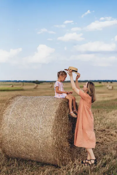 하늘을 밀밭에서 엄마와 베일에 앉아있다 엄마는 그녀의 모자를 넣습니다 로열티 프리 스톡 이미지
