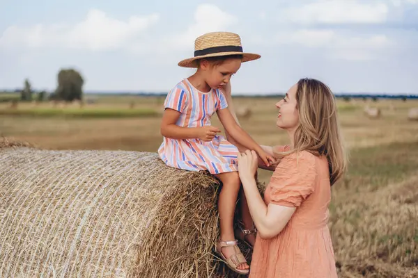 하늘을 밀밭에서 엄마와 베일에 앉아있다 엄마는 그녀의 모자를 넣습니다 로열티 프리 스톡 사진