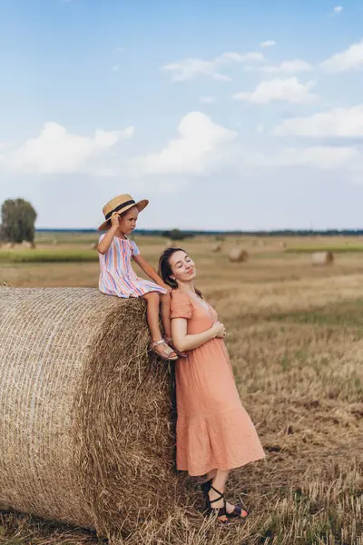 하늘을 밀밭에서 엄마와 베일에 앉아있다 엄마는 베일에 기대어 그녀의 감았습니다 로열티 프리 스톡 이미지